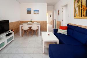 a living room with a blue couch and a table at Casa Santo front beach in Cala del Moral