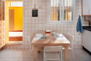 a kitchen with a wooden table and white chairs at Casa Santo front beach in Cala del Moral