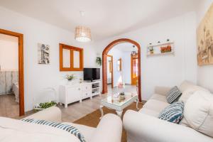 a living room with a white couch and a table at Casa Cantino in Santa Margalida