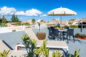 a patio with an umbrella and a table and chairs at Casa Cantino in Santa Margalida