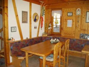 a dining room with a wooden table and a couch at Am Neuhausbauernhof in Königsfeld im Schwarzwald