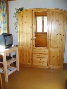 a wooden cabinet with a television in a room at Am Neuhausbauernhof in Königsfeld im Schwarzwald