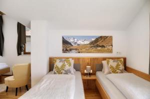 two beds in a room with mountains in the background at Zillertalblick in Zellberg