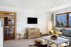 a living room with a couch and a tv on a wall at Zillertalblick in Zellberg