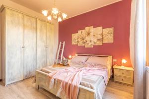 a bedroom with a bed and a red wall at Casa Vacanze Mongili - Il Moro in Chiusi +36 photos