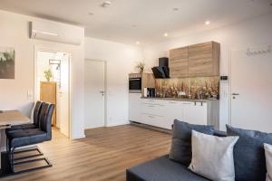 a living room with a couch and a table and a kitchen at Fewo Schmidt in Bahlingen