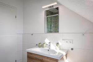 a white bathroom with a sink and a mirror at Fewo Schmidt in Bahlingen +19 photos