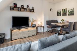 a living room with a couch and a television at Fewo Schmidt in Bahlingen