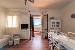 a room with a bedroom with a bed and a television at Casa Nicoleup in Porto Columbu - Perdʼe Sali