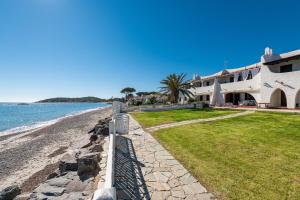 a house on the beach next to the ocean at Casa Nicoleup in Porto Columbu - Perdʼe Sali
