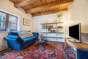 a living room with a blue couch and a tv at Alte Polsterei in Nienstädt
