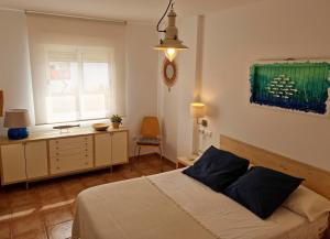 a bedroom with a bed and a dresser and a window at Edificio can Sord Apto nº 2 in La Savina