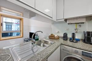 a kitchen with a sink and a washing machine at Mary House in Matosinhos