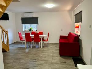 a living room with a table and red chairs at Gaj za Rzeką GNAP in Prusie +8 photos