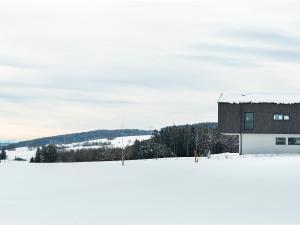 a building on top of a snow covered field at Chalet Am Ried in Bad Wurzach