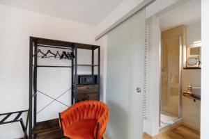 an orange chair in a room with a closet at Pension Waldliesel in Dornstetten +130 photos