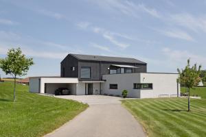 a black and white house with a driveway at Chalet Am Ried in Bad Wurzach