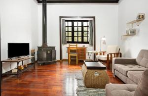 a living room with a couch and a stove at Casa Rural La Escalerilla in Teror