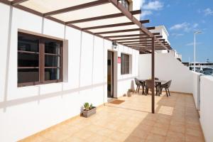 a white house with a patio with a table and chairs at Casa Candido in Playa Honda