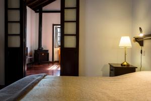 a bedroom with a bed and a lamp on a table at Casa Rural La Escalerilla in Teror +37 photos