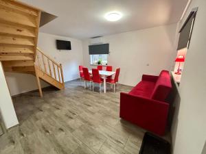 a living room with a red couch and a table at Gaj za Rzeką GNAP in Prusie