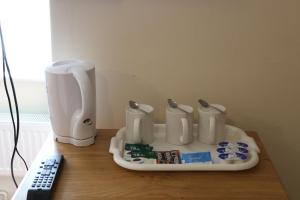 a table with a coffee maker and a remote control at Acorn Lodge Guest House - Free parking in Gosport