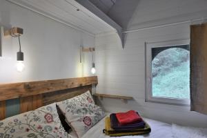a small bedroom with a bed and a window at Roulotte Appoline in Arrien-en-Bethmale