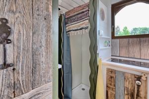 a bathroom with a sliding door and a sink at Roulotte Appoline in Arrien-en-Bethmale