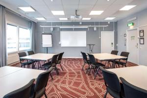 a classroom with tables and chairs and a whiteboard at Scandic Linköping Väst in Linköping +25 photos