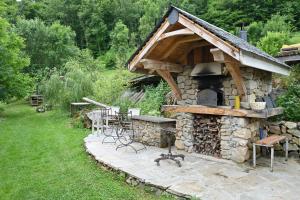 a stone oven with a table and chairs outside at Roulotte Appoline in Arrien-en-Bethmale