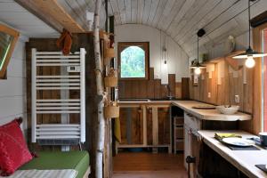 a kitchen in a tiny house with a window at Roulotte Appoline in Arrien-en-Bethmale +13 photos