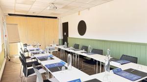 a row of tables in a room with chairs at Campanile L'Isle d'Abeau - Bourgoin Jallieu in LʼIsle-dʼAbeau