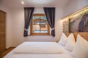 a bedroom with a bed and a window at Lechnerhof Fane Alm in Valles