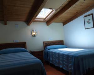 two beds in a room with a window at Granados in Fuenteheridos