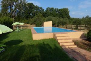 a swimming pool with stairs next to a grass yard at Granados in Fuenteheridos