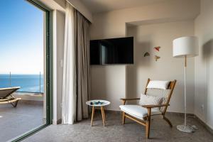 a living room with a chair and a television at Joy Horizon in Skala