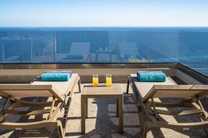 two tables and chairs on a balcony with a view at Joy Horizon in Skala