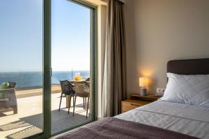 a bedroom with a bed and a balcony with a table at Joy Horizon in Skala