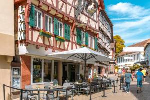 Eine Straße mit Tischen und einem Sonnenschirm vor einem Gebäude in der Unterkunft Hotel & Restaurant Lamm in Mosbach