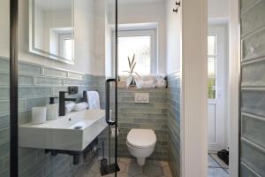 a bathroom with a toilet and a sink at Ferienhaus Düün Drööm in Ording +21 photos