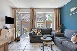 a living room with a couch and a tv at Ferienhaus Düün Drööm in Ording