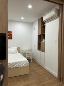 a small bedroom with a bed and a desk at Căn hộ Republic Plaza gần Tân Sơn Nhất airport in Kon Rung (1)