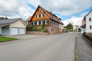 an empty street with a brown house on the side of the road at Ferienwohnung Malia in Neubulach
