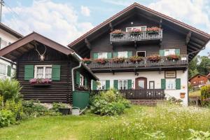 a wooden house with flower boxes on the balconies at Ferienwohnung Lengdobler - Leni in Bad Kohlgrub