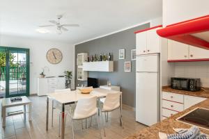a kitchen and dining room with a white table and chairs at Casa Real in Playa Blanca
