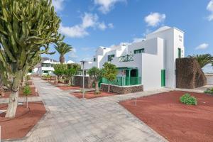 a white building with trees in front of it at Casa Real in Playa Blanca +12 photos