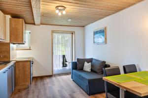 a living room with a blue couch and a table at Ferienwohnung Lengdobler - Leni in Bad Kohlgrub
