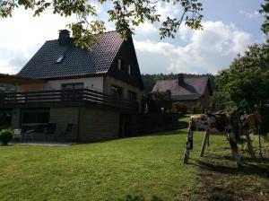 a statue of a cow in front of a house at Ferienhaus Dell in Möhnesee