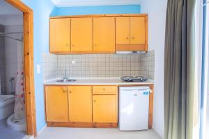 a kitchen with yellow cabinets and a white refrigerator at Nidri view Apartments in Nydri