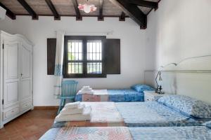 a bedroom with two beds and a window at Casa sul lago private heated pool in Dorgali +35 photos